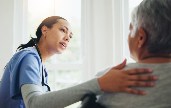 Photo of a Home Health Provider comforting an elderly female patient